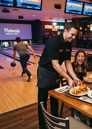 A server bringing food to guests at a lane-side table