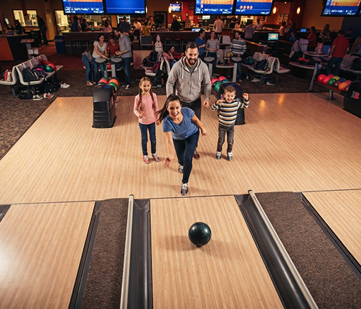 A family cheering while bowling together