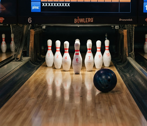 A bowling ball rolling toward a full rack of pins